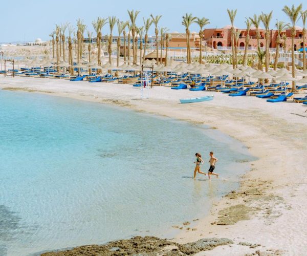 Pickalbatros Villaggio Resort Portofino in Marsa Alam het strand bij de lig bedjes